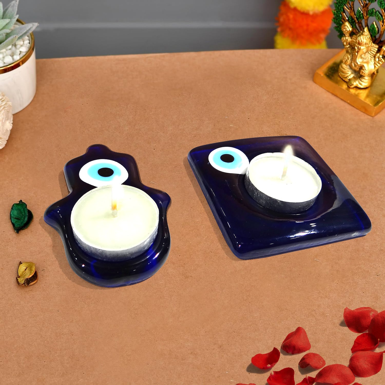 Two blue candle holders with white candles on a brown surface.