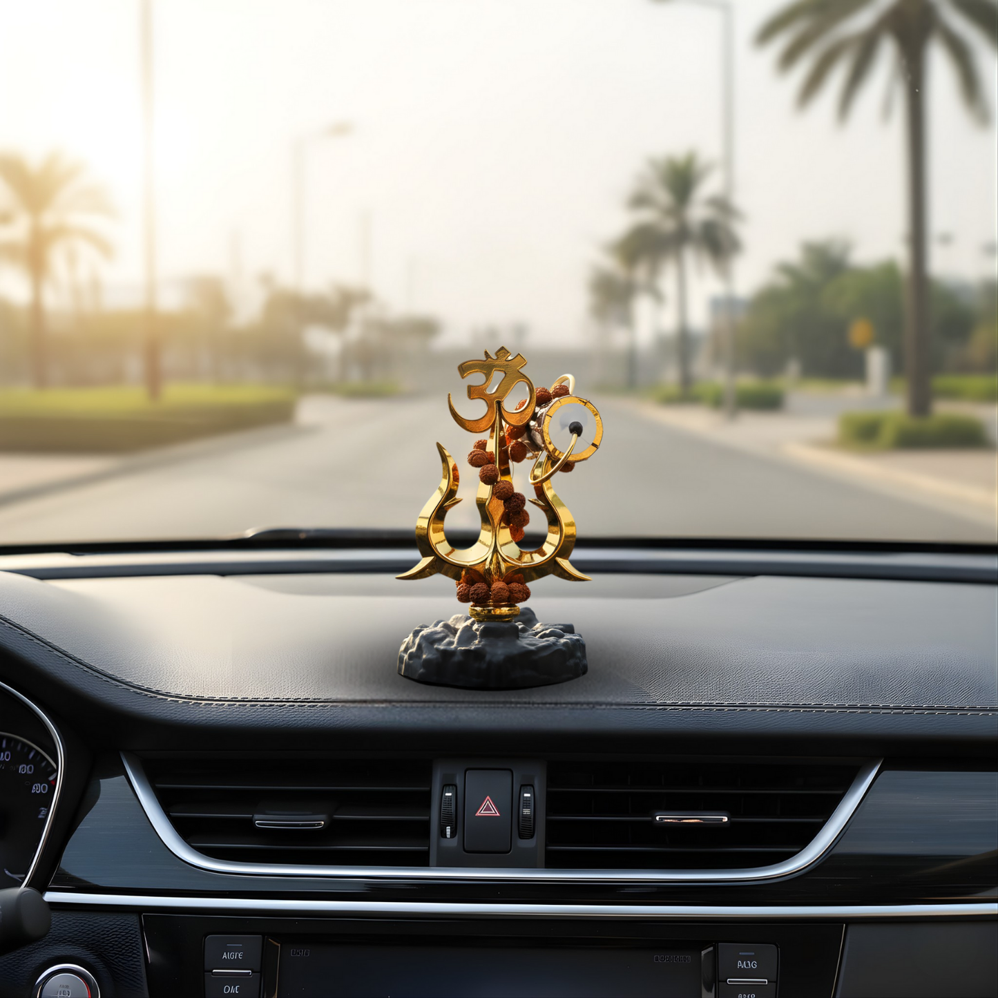 Decorative Shiva Trishul on a car dashboard with palm trees in the background