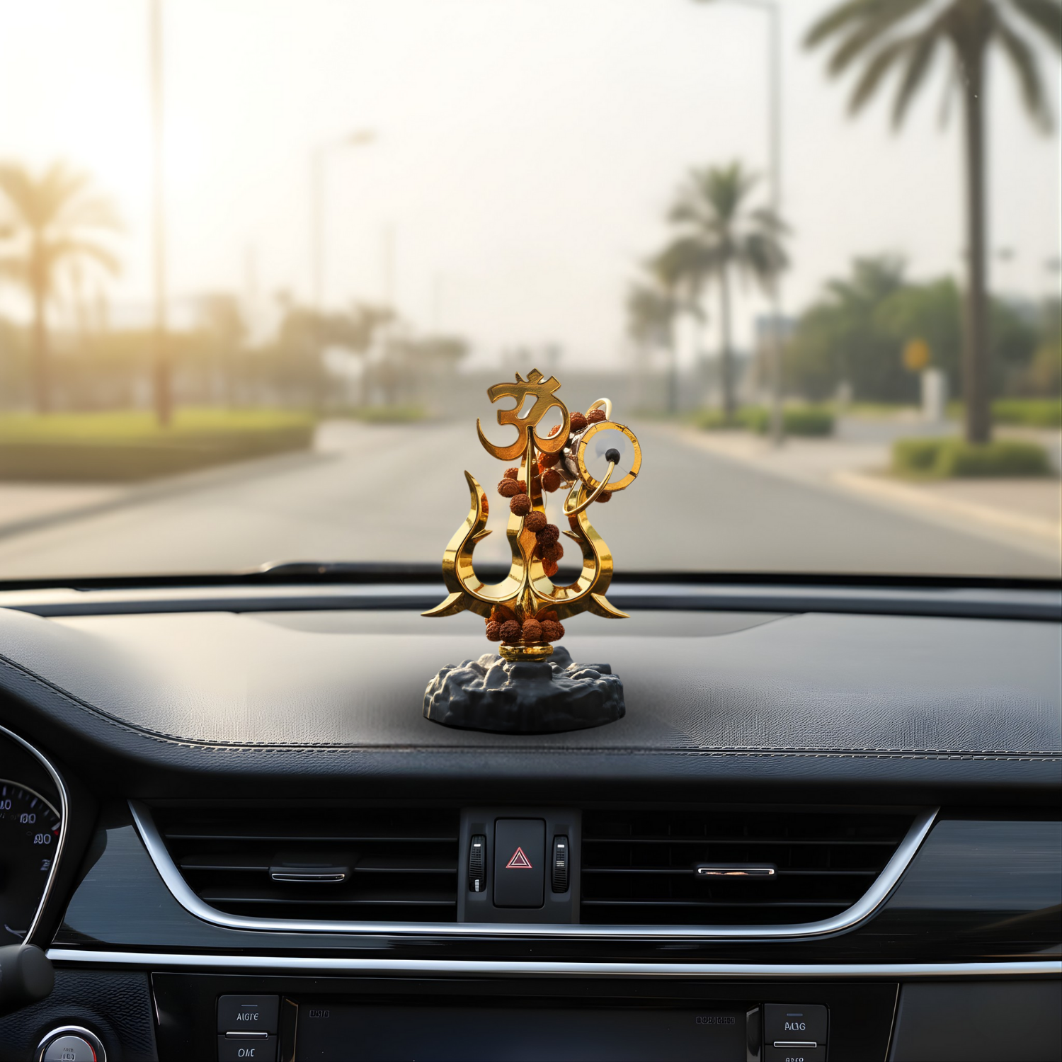 Decorative Shiva Trishul on a car dashboard with palm trees in the background
